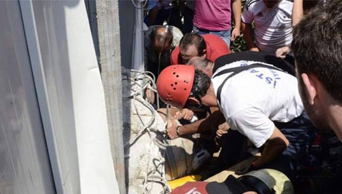 Kepçe ile yıkılan binadan kopan beton, bekçinin üstüne düştü