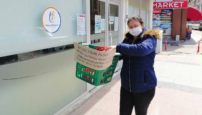 Balkondan sarkıttığı sepetle ihtiyacı olanlara yardım ediyor