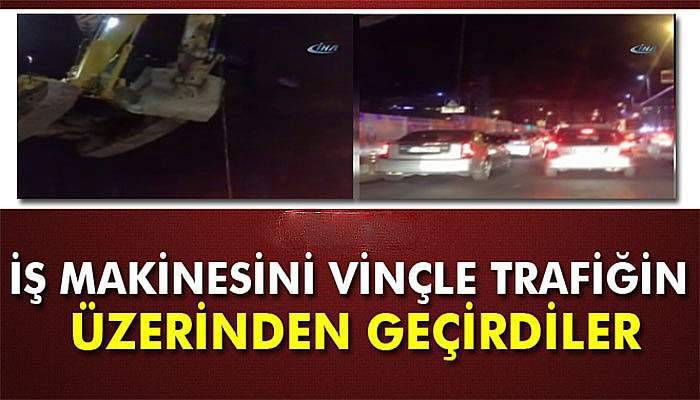 İş makinesini vinçle trafiğin üzerinden geçirdiler